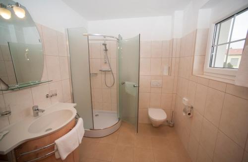 a bathroom with a shower and a sink and a toilet at Villa Katharina in Rust