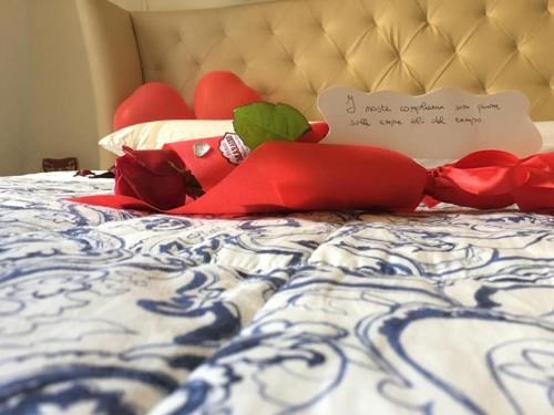 a bed with red pillows and a sign on it at Alla dimora di Chiara Suite and Rooms in Matera