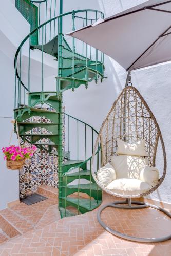 a swinging chair in front of a spiral staircase at Groundfloor in Faro