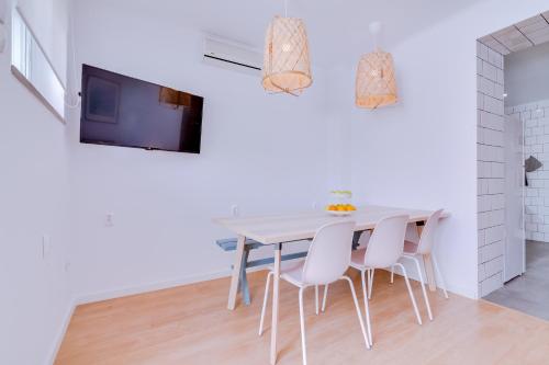 Un comedor blanco con una mesa y sillas. en Groundfloor, en Faro