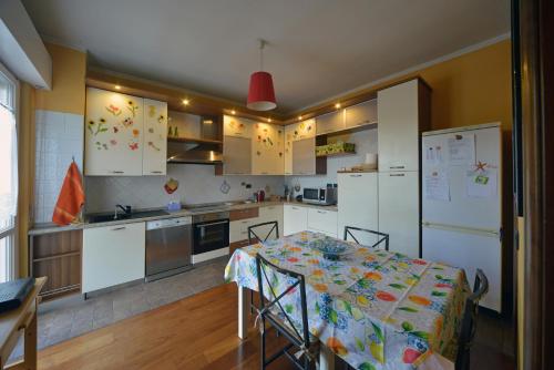 a kitchen with a table and a kitchen with white appliances at Casa Amadi 2 - La tua casa lontano da casa in Brescia