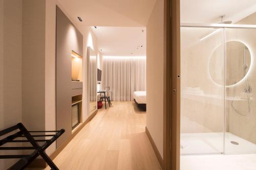 a bathroom with a shower and a bedroom at Zenit Convento San Martin in San Sebastián