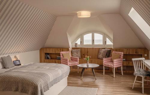 a bedroom with a bed and a table and chairs at Strandhaus Ahrenshoop in Ahrenshoop