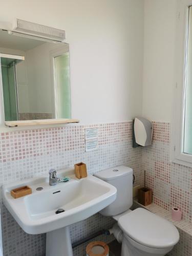a bathroom with a white sink and a toilet at Le Saint Jean in Barbentane