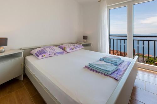 1 dormitorio con 1 cama y vistas al océano en One-Bedroom Apartment Crikvenica near Sea 9, en Klanfari