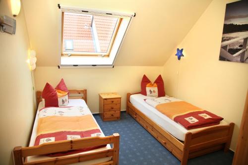 two beds in a small room with a window at Das Müritz Haus in Rechlin