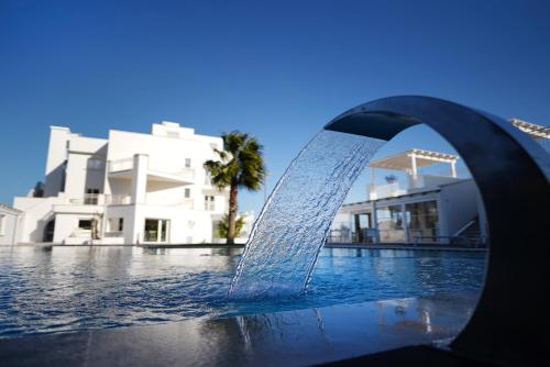 une fontaine au milieu d'une piscine dans l'établissement San Lorenzo Boutique Hotel & SPA, à Polignano a Mare
