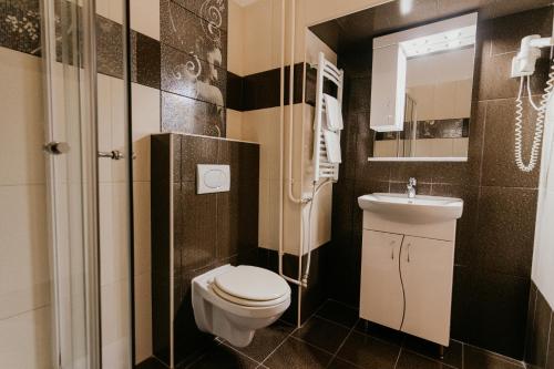 a small bathroom with a toilet and a sink at Tisza Hotel in Szeged