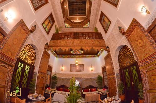 フェズにあるRiad Fes Madawの建物内のテーブルと椅子のあるレストラン