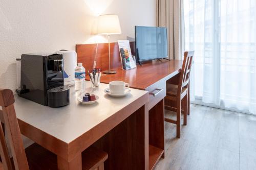 a kitchen with a table and chairs and a microwave at Residhotel Grenette in Grenoble