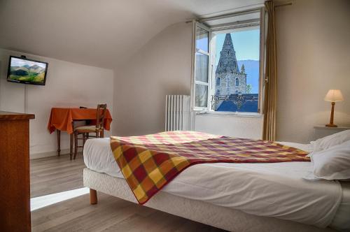 a bedroom with a bed with a view of a castle at Hotel du Col de l'Arc in Lans-en-Vercors