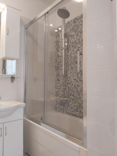 a shower with a glass door in a bathroom at Apartman Apollo 2 Makarska in Makarska