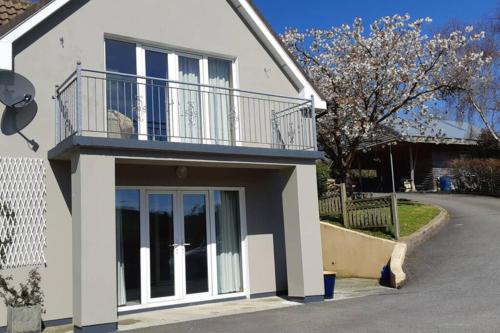 a white house with a balcony on top of it at Tir na nOg - A Piece of Heaven in Bantry