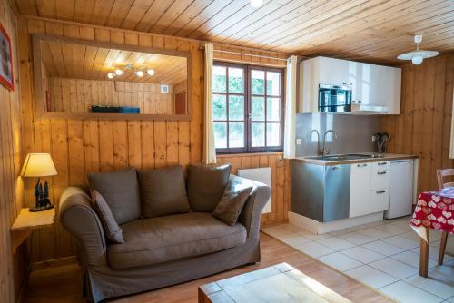 a living room with a couch and a kitchen at Le Diable Bleu in Lamoura