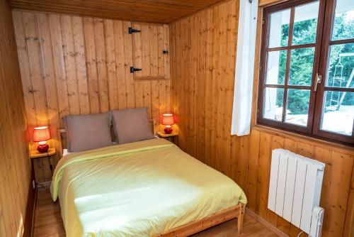 - une chambre avec un lit dans une pièce en bois dans l'établissement Le Diable Bleu, à Lamoura