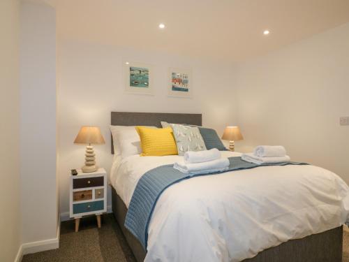 a bedroom with a large bed with towels on it at Midships in St Austell
