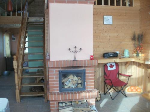 a room with a brick fireplace and a red chair at Talsu Pirtiņa Vijoles in Talsi