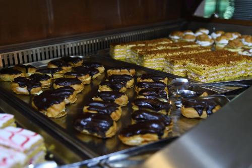 a display case with a bunch of donuts and other pastries at Hotel Delta 3 in Tulcea