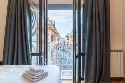 a bedroom with a view of a city from a window at 900 Apartments in Rome