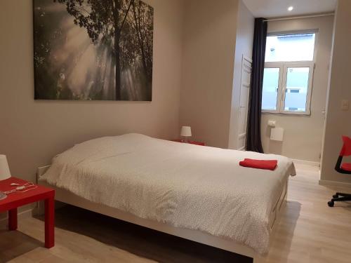a bedroom with a bed and a painting on the wall at Central Yellow Apartment in Brussels