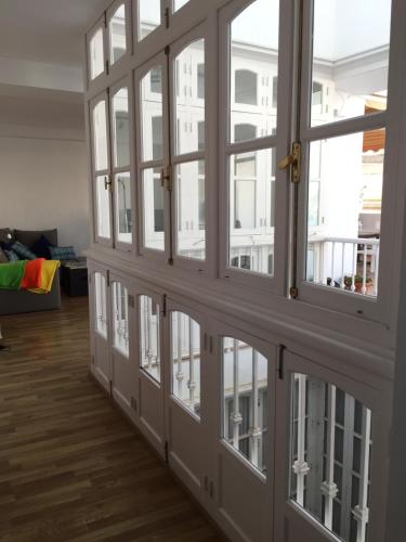 - une rangée de fenêtres dans le salon doté de parquet dans l'établissement La terraza de San Pedro, à Cadix