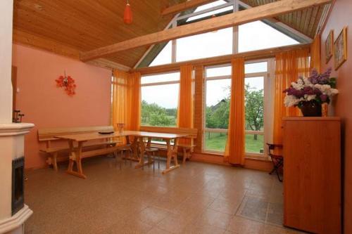 ein Wohnzimmer mit einem Tisch und einem großen Fenster in der Unterkunft Talsu Pirtiņa Vijoles in Talsi
