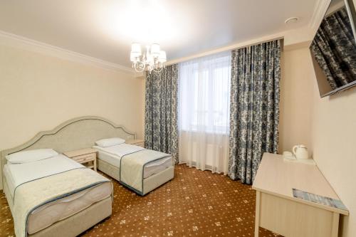 um quarto de hotel com duas camas e uma janela em Hotel Aquamarin em Surgut