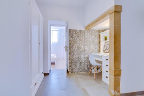a white bathroom with a sink and a desk at Groundfloor in Faro