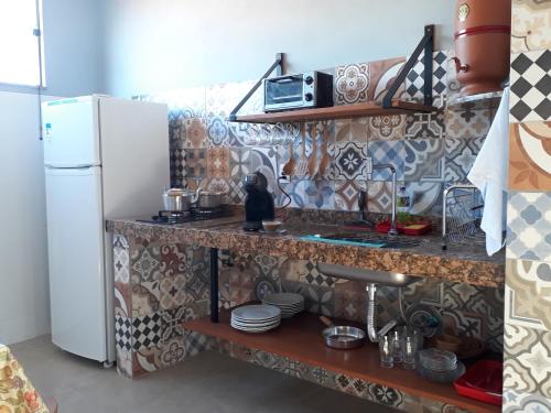 a kitchen with a sink and a refrigerator at Dama 2 in Tiradentes