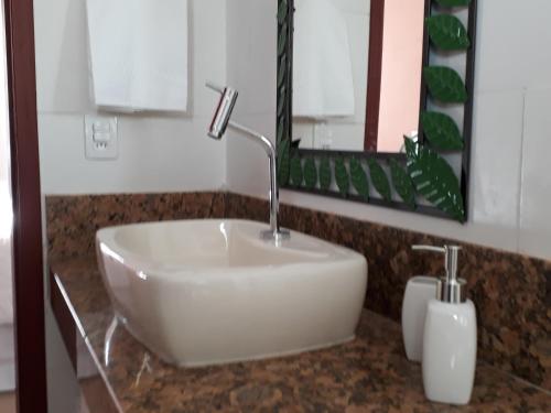 a white sink in a bathroom with a mirror at Dama 2 in Tiradentes