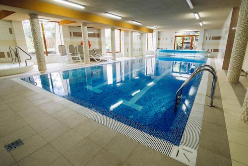 a large swimming pool in a hotel room at Apartamenty Sun & Snow Pacyfik Spa z basenem in Kościelisko