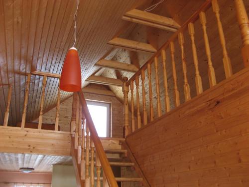 a staircase in a wooden cabin with a red light at Talsu Pirtiņa Vijoles in Talsi