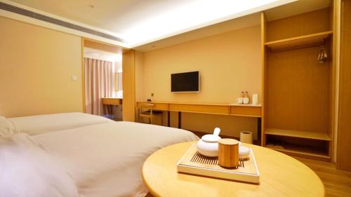 a hotel room with two beds and a table at Hanting Youjia Hotel (Dali Erhai Park) in Dali