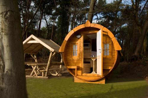 a small wooden hobbit house with a tree at Costa Kabrita in Huijbergen