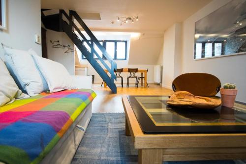 a living room with a bed and a table at Charming Triplex near Avenue Louise in Brussels