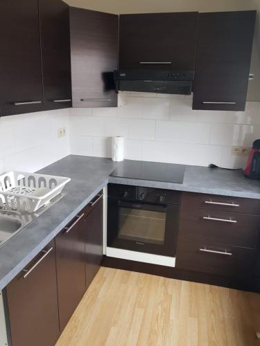 a kitchen with black cabinets and a sink and a stove at Central Yellow Apartment in Brussels