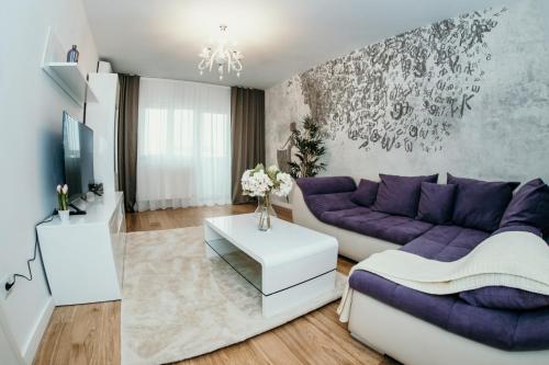 a living room with a purple couch and a tv at Apartament de lux ultramodern in zona centrala in Timişoara