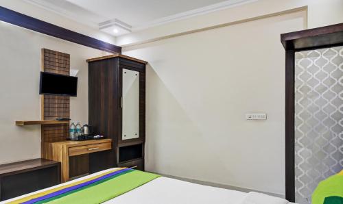 a bedroom with a bed and a tv and a mirror at Treebo Royal Sun Palace MP Nagar Zone 2 in Bhopal