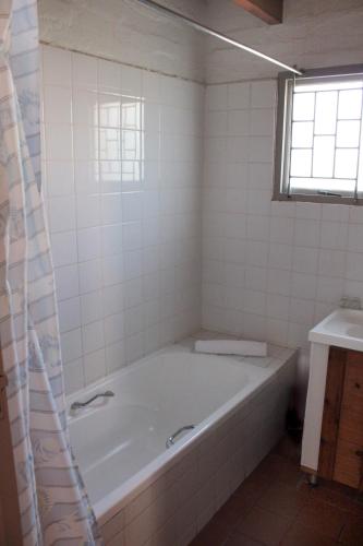 a white bath tub in a bathroom with a window at Blue Bay Lodge in Saldanha