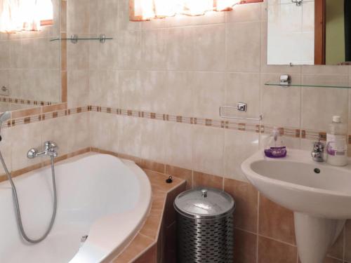 a bathroom with a sink and a tub and a toilet at Tamás Ház in Balatonőszöd