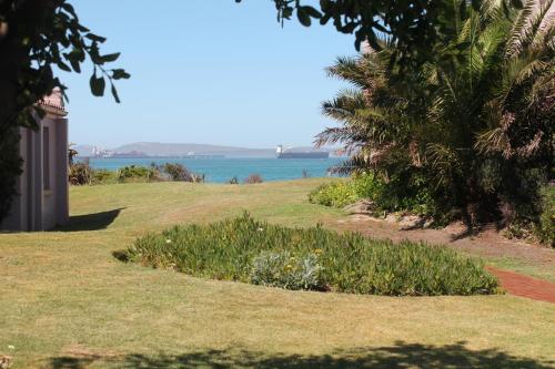 a grassy area with a view of the water at Blue Bay Lodge in Saldanha