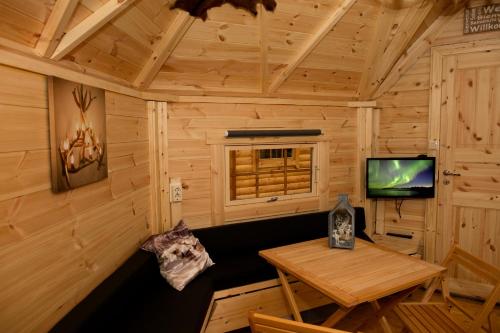 a room with a table and a television in a cabin at Costa Kabrita in Huijbergen