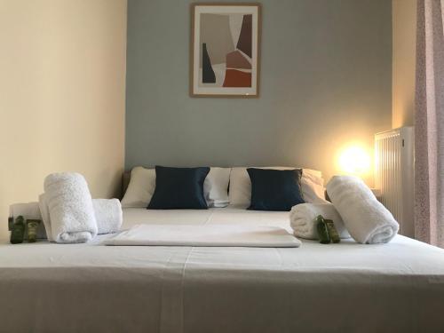 a large bed with white sheets and pillows on it at Irini Apartments in Kavala