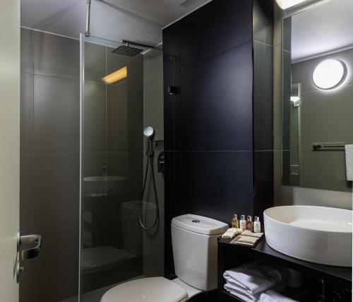 een badkamer met een douche, een toilet en een wastafel bij Brown Seaside a member of Brown Hotels in Tel Aviv