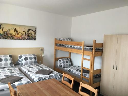 a room with two bunk beds and a table at Penzion Amálka in Třeboň