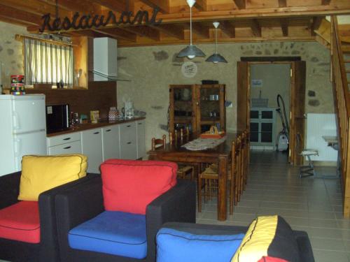une cuisine avec des chaises colorées et une table. dans l'établissement Cellier de la Fontaine, à Saint-Georges-en-Couzan