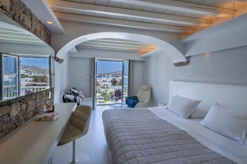 a bedroom with a large bed and a large window at Semeli Hotel Mykonos in Mikonos