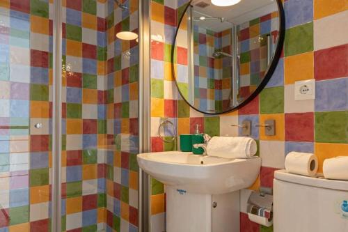 een badkamer met een wastafel en een spiegel bij Becas Alameda Duplex by Valcambre in Sevilla