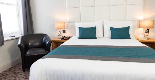 a hotel room with a bed and a chair at Kingscliff, BW Signature Collection in Clacton-on-Sea