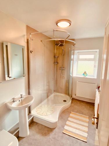 a bathroom with a shower and a sink at Hawkshead Cottage in Glossop